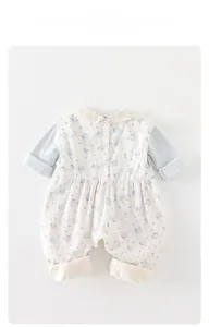 Detail of floral baby romper featuring delicate white lace collar and three-button back