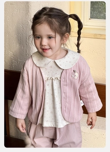 Detailansicht der rosa Strickjacke für Mädchen mit Blumenhemd und Größenetikett