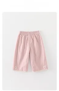 Detail of pink wide-leg toddler pants featuring floral accents and delicate lace edges