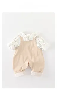Dettaglio completo neonata con camicia a maniche lunghe cuori e pantaloni a bretelle