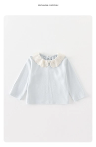 Detail of baby girl light blue cotton top with exquisite white lace Peter Pan collar