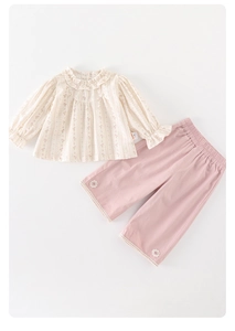 Close-up of floral beige long sleeve top with ruffles and pink lace wide-leg pants