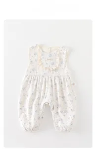Close-up of baby floral romper featuring delicate lace collar and handmade label details