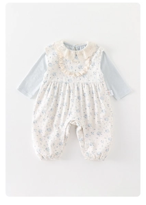 Detail of baby floral bodysuit featuring lace embroidery collar and handmade label