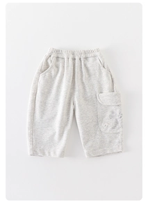 Détail d'un pantalon de jogging en coton gris avec taille élastique et poche dessin animé