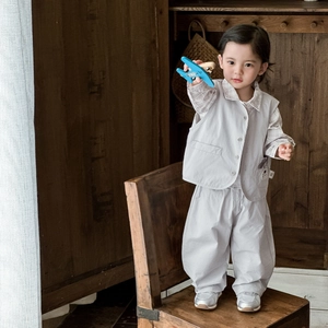 Toddler boy 3-piece set with grey vest, plaid shirt and casual pants on a chair