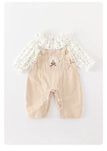 Dettaglio di camicia a maniche lunghe stampa cuore e salopette beige con ricamo a coniglio