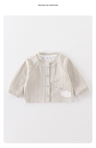 Detail der baby-cremefarbenen Strickjacke mit Vier-Knopf-Verschluss und süßem Aufnäher