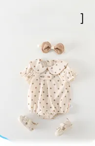 Detailed flat lay of baby polka dot romper set with matching headband and sandals