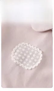 Détail d'un sweat rose pour bébé avec patch brodé en dentelle de marguerites blanches