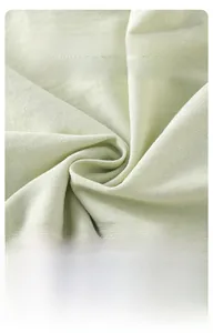 Close-up of light green combed cotton fabric showing soft knit texture and breathable weave