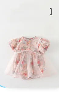 Dettaglio di pagliaccetto rosa floreale per neonata con pizzo e gonna in tulle
