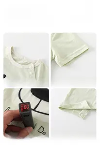 Details of green cotton baby bodysuit showing snap buttons and fluorescent-free fabric