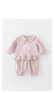 Détail de l'ensemble deux pièces rose pour bébé fille avec dentelle et ourlet volanté