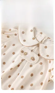 Detail of baby bodysuit peter pan collar with polka dots and wooden buttons