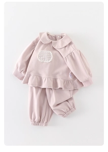 Détail de l'ensemble bébé fille en maille gaufre rose avec col Claudine et volant