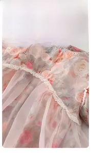 Dettaglio della pagliaccetta rosa a fiori per neonata con pizzo e morbido tessuto tulle