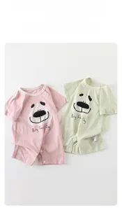 Detail view of cotton baby bodysuits showing round neck and snap button closure features
