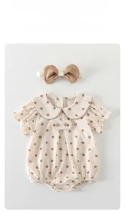Detail of infant polka dot romper with Peter Pan collar and matching bow headband