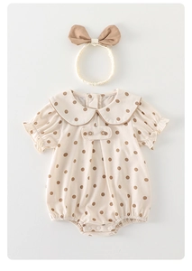 Detail of baby polka dot romper showing Peter Pan collar and matching bow headband