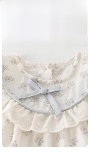 Detail shot of baby girl floral cotton top with ruffled collar and grey bow ornament