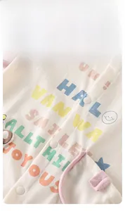 Makrodetail eines Baby-Stramplers mit bunten Kunstdrucken und weißen Druckknöpfen
