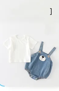 Detail of baby denim romper set showing bear embroidery and button-up shoulder straps