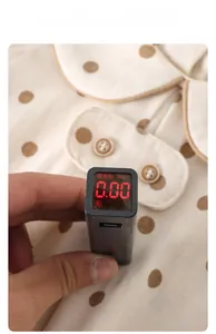 Macro shot of a black detector showing 0.00 fluorescence on beige polka dot baby clothing