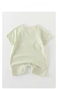 Close-up of breathable light green cotton newborn romper with contrasting crew neckline