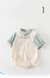 Detail of baby summer romper with traditional Chinese knot and elegant magnolia pattern