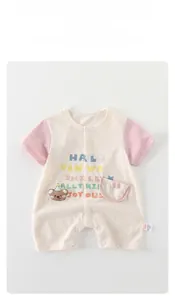 Detail von Baby Baumwoll-Strampler mit Teddybär-Stickerei und bunten Aufdrucken im Fokus
