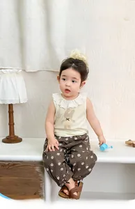 Detail of toddler summer outfit with lace collar rabbit top and floral pants
