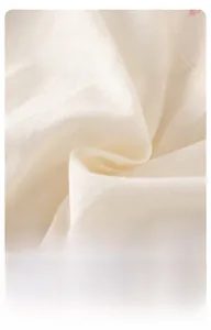 Détail du tissu en coton blanc cassé respirant pour ensemble gilet bébé fille