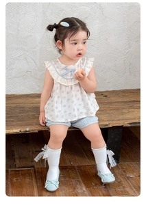 Detail of floral baby girl blouse with ruffled collar and matching blue bloomers