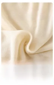 Close-up of soft beige knit fabric showing breathable texture for baby clothing