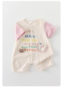 Detail eines Baby-Baumwoll-Stramplers mit Regenbogen-Print und süßem Bären-Patch