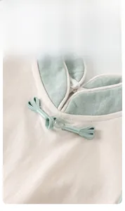 Detail of traditional Chinese Pankou knot on cream cotton baby bodysuit neckline
