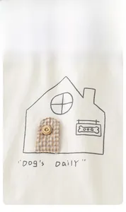 Close-up of baby cotton vest featuring a cartoon house design with fabric door detail