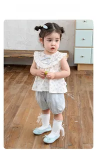 Detailed view of floral sleeveless top with blue bow and light blue cotton shorts for girls