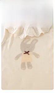 Detail of baby sleeveless top featuring lace collar, bunny print and brown bow accent