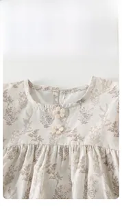 Detail of floral baby girl top featuring a square neck with 3D knitted flower decorations
