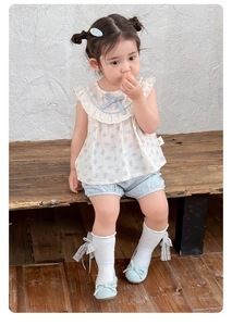 Detail of girls' floral ruffle top and blue bloomer shorts with lace accessories