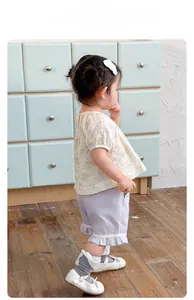 Details des Mädchen-Sommersets mit beigem Spitzenoberteil und lila Rüschenshorts