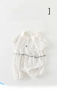 Détails de barboteuse bébé avec col en dentelle et motif de nœuds noirs sur coton