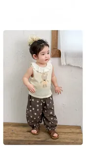 Detail of baby summer set featuring lace collar bunny top and floral print pants