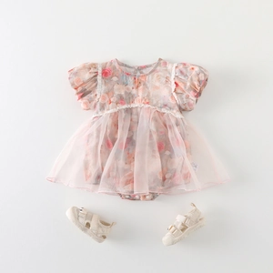 Body da neonata in rete rosa floreale e sandali color crema su sfondo bianco