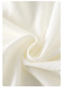 Macro d'un tissu en coton blanc doux montrant une texture fine et une grande souplesse