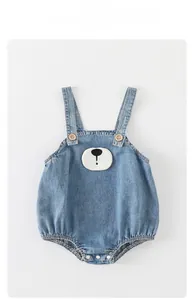 Detail of baby denim romper featuring bear embroidery and adjustable wooden buttons