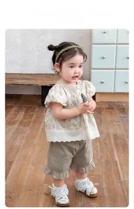 Detail of floral puff sleeve top with lace trim and ruffled shorts for girls