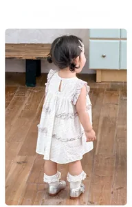 Détail de la robe fleurie en coton avec bouton au dos et volants pour petites filles